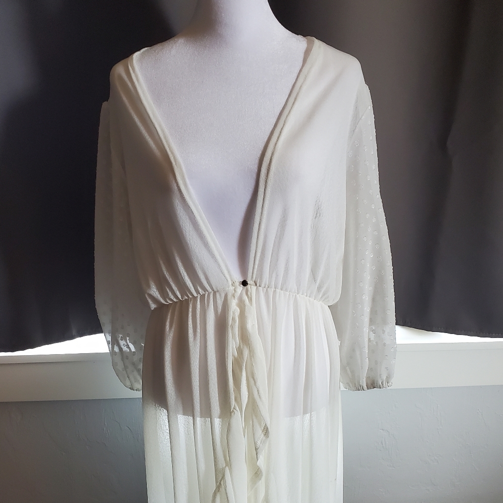 Ember Cream duster or swimsuit cover up with puff sleeves and eyehook closure .